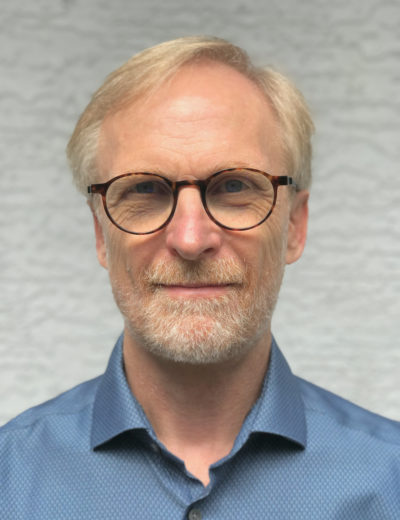 Headshot of an old white man with glasses